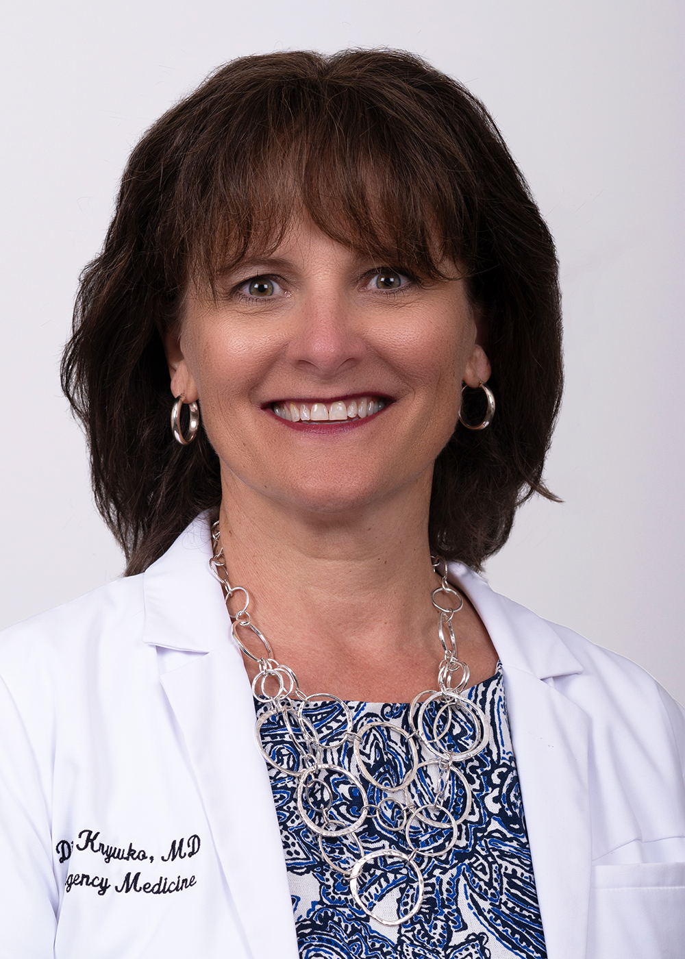 Diann Krywko, Briggs alum and distinguished professor of emergency medicine, wears a white coat